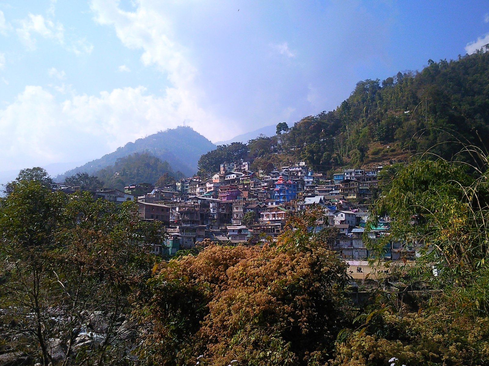 Bijanbari town in Darjeeling district, West Bengal, spread across a green Himalayan hillside surrounded by trees and tea gardens