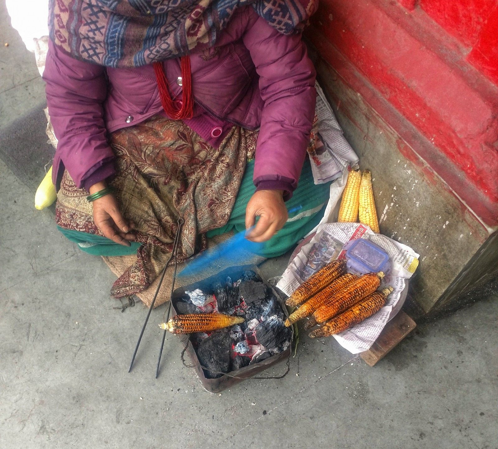 Roasted corn cobs cooking on charcoal at a street food seller on Mall Road Darjeeling