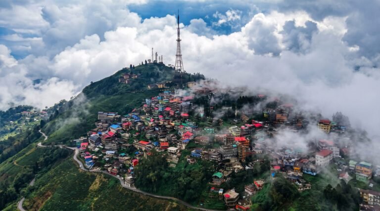 Aerial view of Kurseong hill town with colourful rooftops among clouds